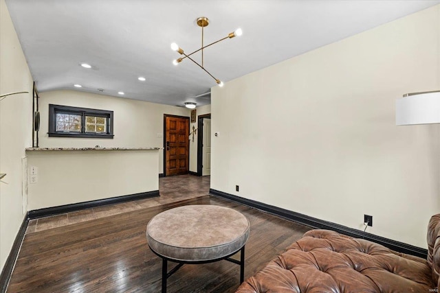 interior space with dark hardwood / wood-style floors, vaulted ceiling, and a notable chandelier