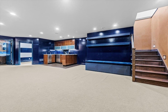 kitchen with stainless steel dishwasher, a kitchen island, and light carpet