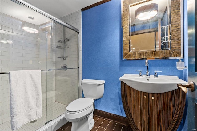 bathroom with vanity, toilet, and a shower with shower door