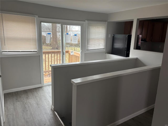 kitchen featuring refrigerator, kitchen peninsula, and light hardwood / wood-style flooring