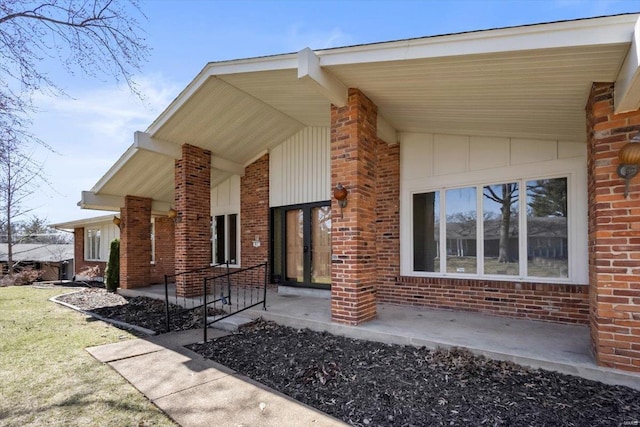 entrance to property with brick siding and board and batten siding