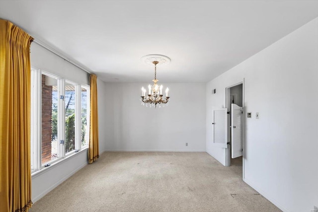 spare room featuring light carpet, baseboards, and a notable chandelier