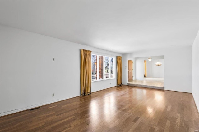 interior space with wood finished floors, visible vents, and a notable chandelier