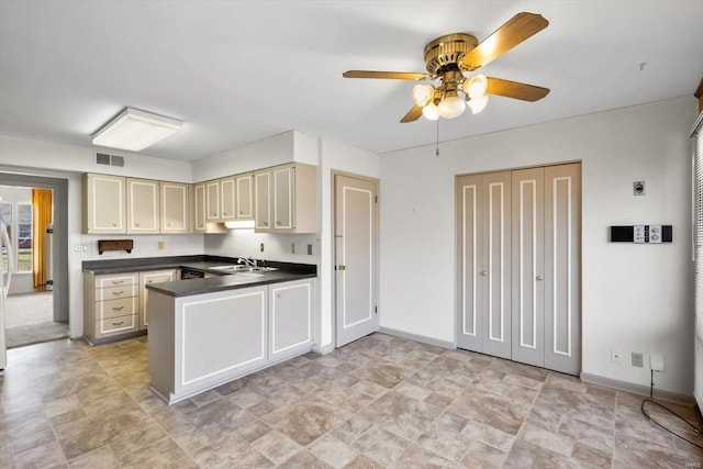 kitchen with a peninsula, visible vents, baseboards, cream cabinetry, and dark countertops