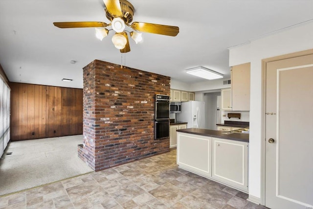 kitchen with dobule oven black, wood walls, white fridge with ice dispenser, stainless steel microwave, and dark countertops