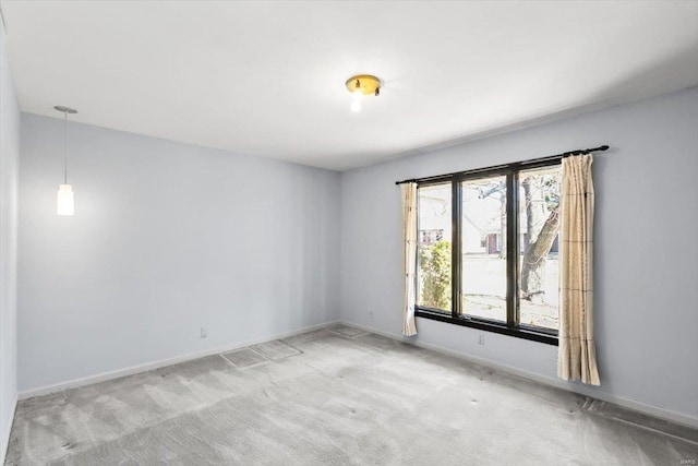 carpeted spare room featuring baseboards