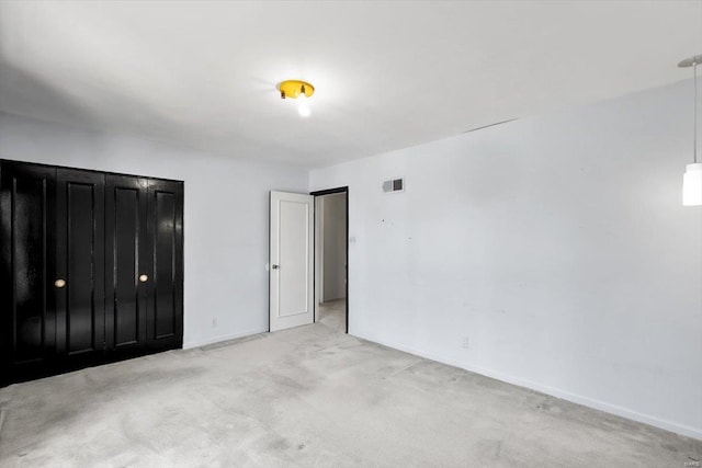 unfurnished bedroom featuring baseboards, visible vents, and light colored carpet