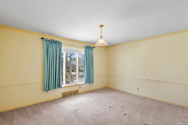 spare room with ornamental molding, carpet flooring, visible vents, and baseboards