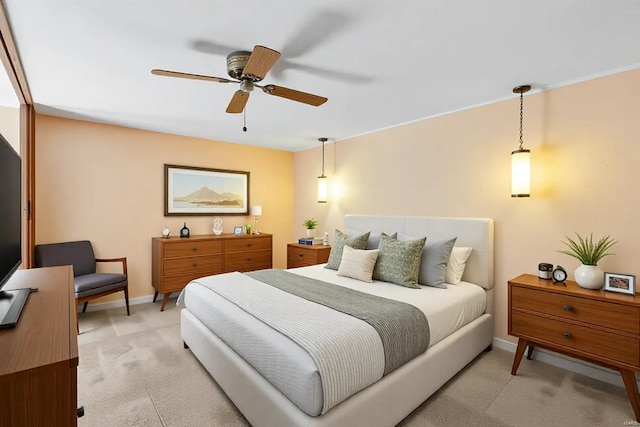 bedroom with ceiling fan, baseboards, and light colored carpet