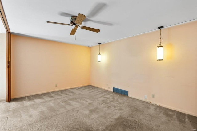 spare room with ceiling fan, carpet, visible vents, and baseboards