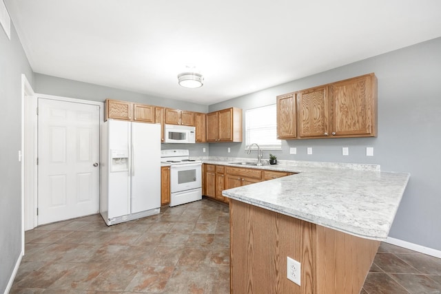 kitchen featuring kitchen peninsula, white appliances, and sink