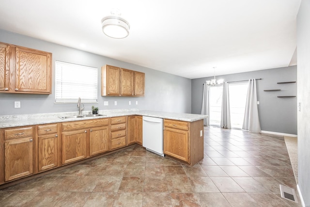 kitchen with hanging light fixtures, kitchen peninsula, plenty of natural light, white dishwasher, and a chandelier