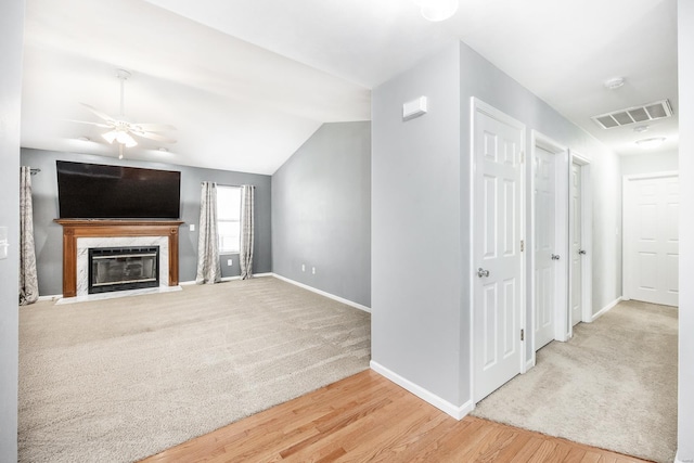 unfurnished living room with hardwood / wood-style floors, ceiling fan, and lofted ceiling