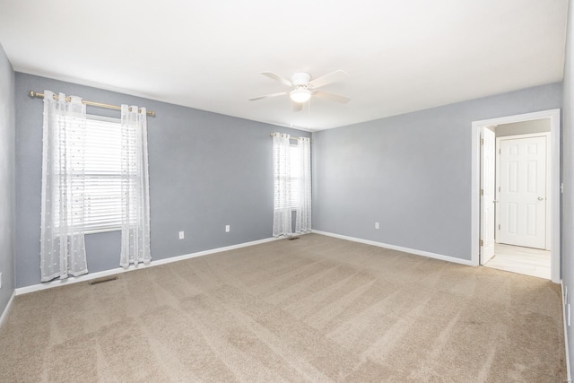 unfurnished room featuring light carpet and ceiling fan