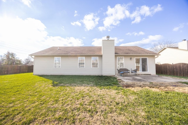 rear view of house featuring a yard and a patio