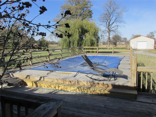 view of pool with a deck, an outbuilding, and a garage