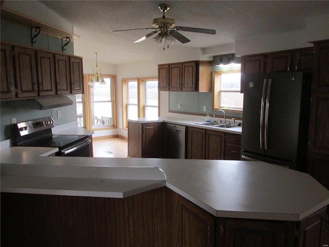 kitchen with a wealth of natural light, appliances with stainless steel finishes, pendant lighting, and sink