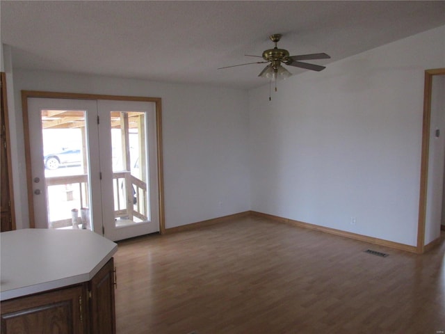 unfurnished living room featuring ceiling fan and hardwood / wood-style flooring