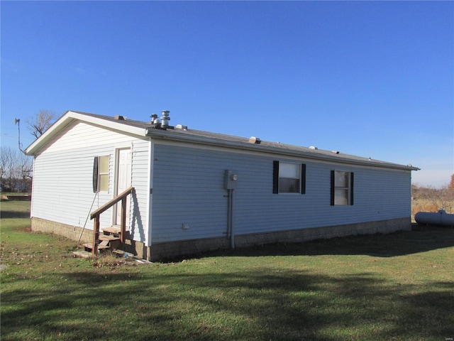 rear view of property featuring a lawn