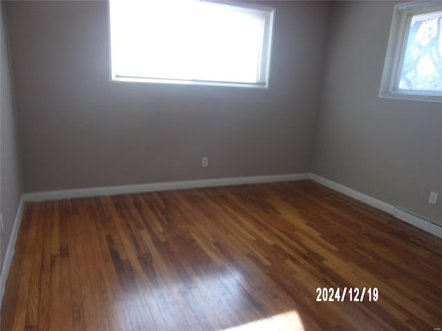 unfurnished room with dark wood-type flooring