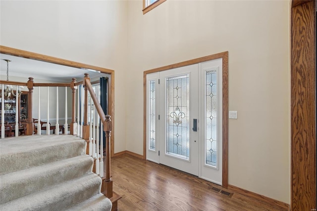 foyer with hardwood / wood-style floors and crown molding