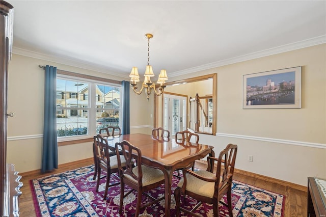 dining space featuring dark hardwood / wood-style floors, crown molding, and an inviting chandelier