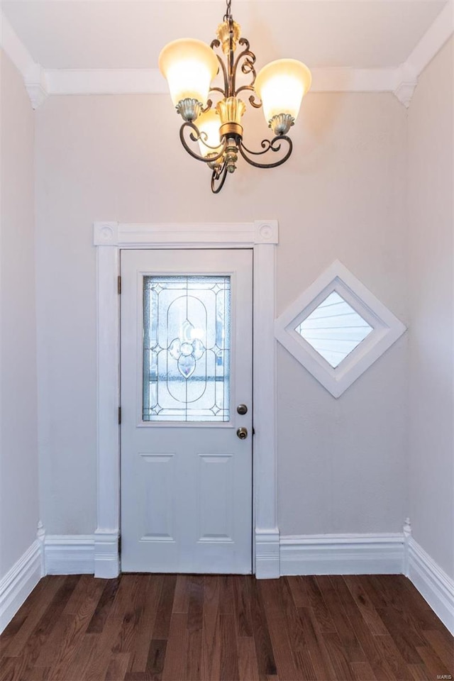 foyer entrance with crown molding, a chandelier, and dark hardwood / wood-style floors