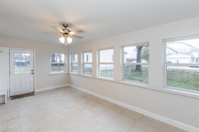 unfurnished sunroom featuring ceiling fan