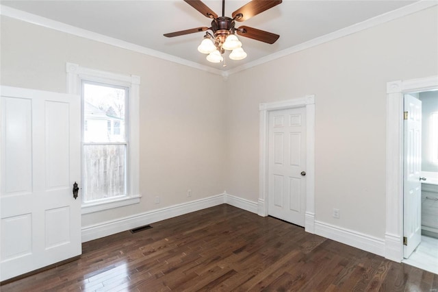 spare room with ornamental molding, ceiling fan, and dark wood-type flooring