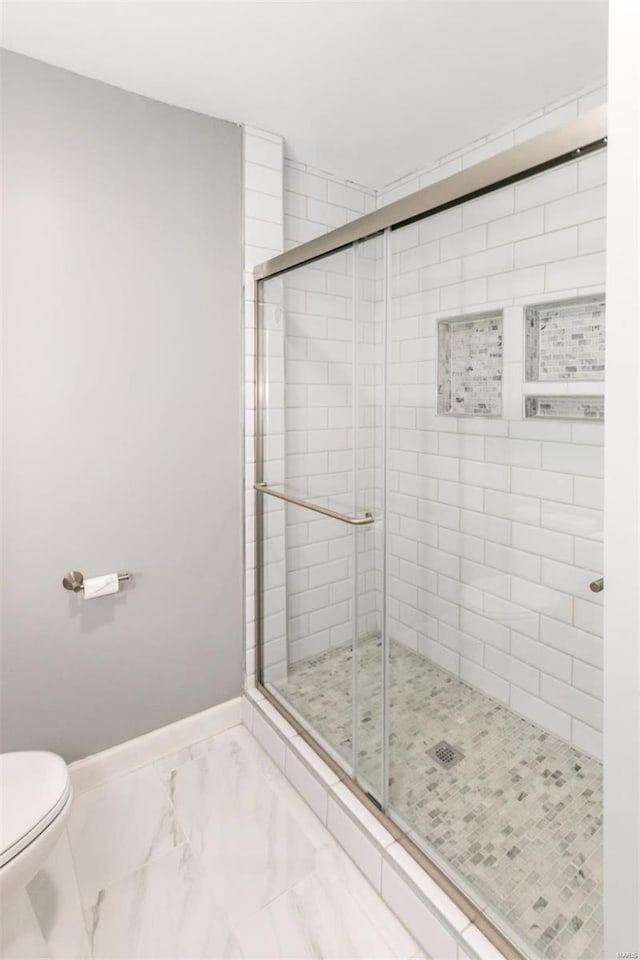 bathroom with toilet and a shower with shower door