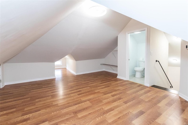 bonus room with lofted ceiling and wood-type flooring