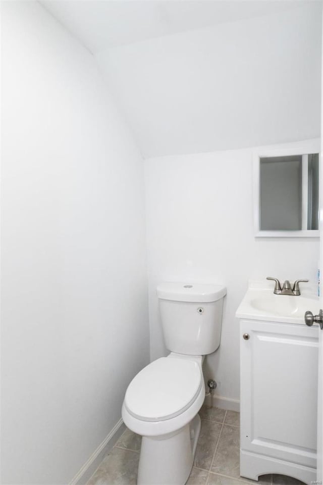 bathroom featuring vanity, vaulted ceiling, and toilet