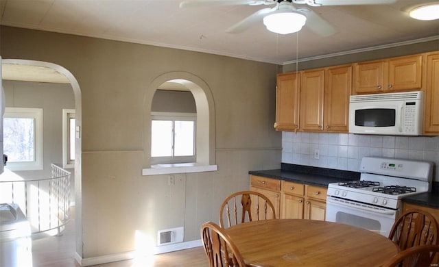 kitchen featuring decorative backsplash, ceiling fan, crown molding, white appliances, and light hardwood / wood-style flooring