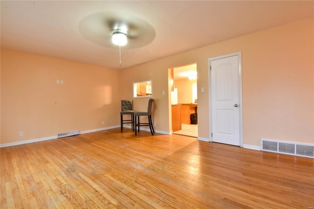 empty room featuring ceiling fan and light hardwood / wood-style flooring