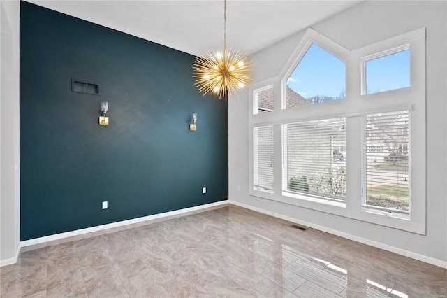 unfurnished room featuring an inviting chandelier