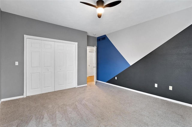 unfurnished bedroom with carpet floors, a closet, vaulted ceiling, and ceiling fan