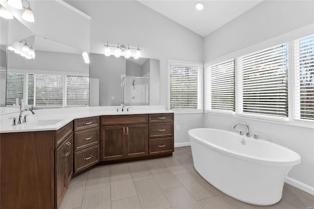 bathroom with vanity, a healthy amount of sunlight, lofted ceiling, and shower with separate bathtub