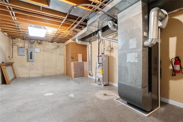 basement featuring electric panel, heating unit, and water heater