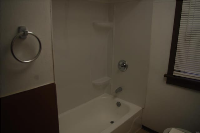 bathroom featuring shower / washtub combination and toilet