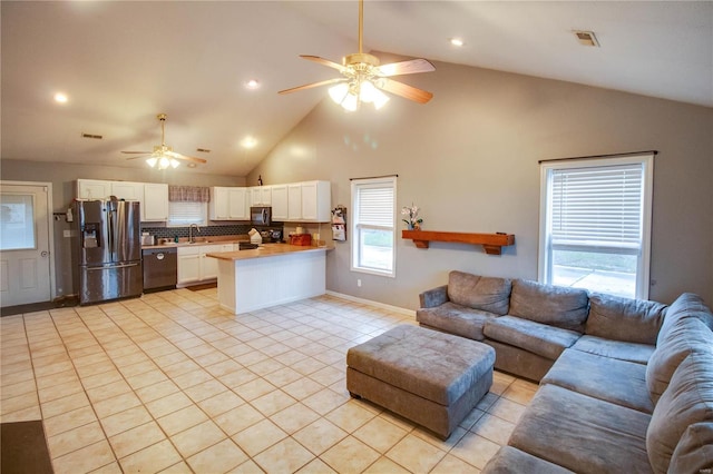 living room with ceiling fan, light tile patterned floors, sink, and high vaulted ceiling