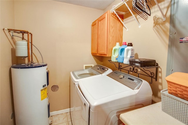 washroom featuring cabinets, light tile patterned flooring, washing machine and dryer, and water heater