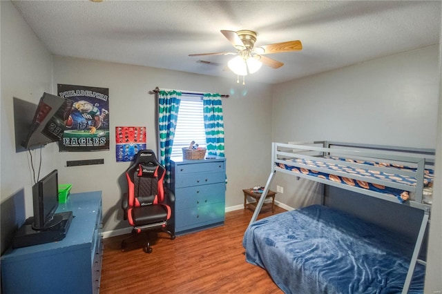 bedroom featuring hardwood / wood-style floors, a textured ceiling, and ceiling fan