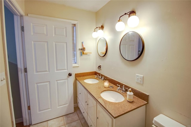 bathroom with toilet, vanity, and tile patterned floors