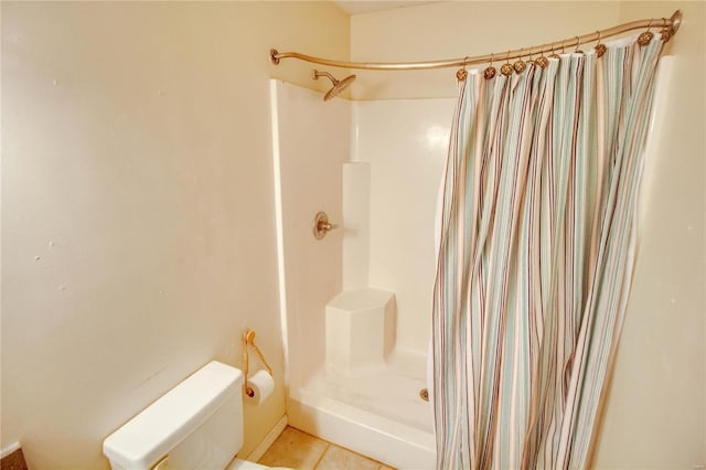 bathroom featuring tile patterned floors, toilet, and walk in shower