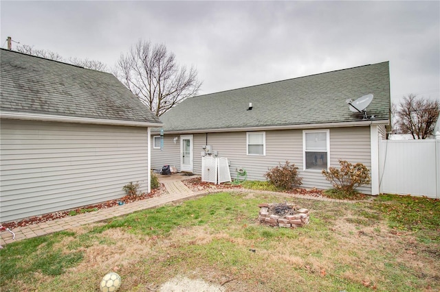 back of property featuring a yard and a fire pit