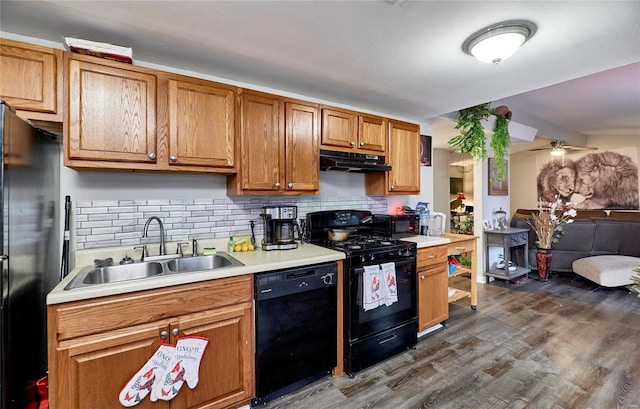 kitchen featuring ceiling fan, sink, dark hardwood / wood-style floors, decorative backsplash, and black appliances