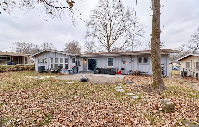 back of house featuring a lawn, an outdoor hangout area, a patio, and central AC unit