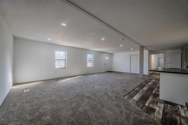 unfurnished living room featuring dark carpet