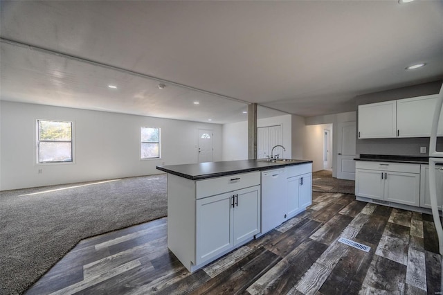 kitchen featuring a center island with sink, white cabinetry, and dark wood-type flooring