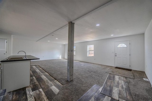 basement featuring dark carpet and sink